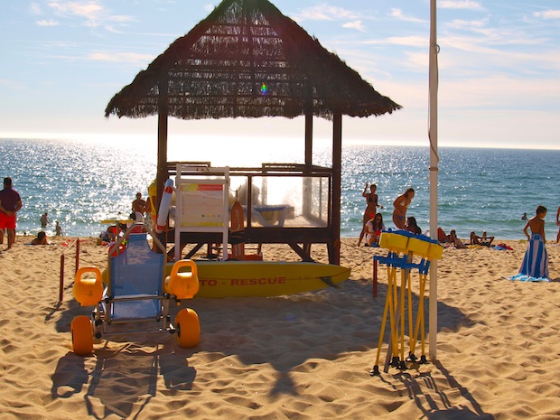 puesto de guardacostas con silla y bastones anfíbios sobre arena de playa