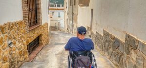 Miguel bajando por calle en pendiente con su silla de ruedas