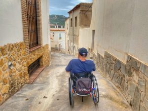 Miguel bajando por calle en pendiente con su silla de ruedas