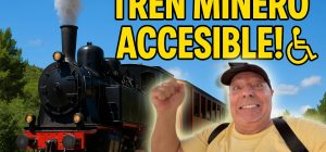 Tren minero accesible en Utrillas circulando con paisaje y cielo azul y Miguel Nonay en primer plano