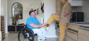 Miguel Nonay en su silla de ruedas junto a su mujer Eva Gutiérrez en su casa de Utebo, en una escena cotidiana de cuidados y complicidad.