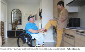 Miguel Nonay en su silla de ruedas junto a su mujer Eva Gutiérrez en su casa de Utebo, en una escena cotidiana de cuidados y complicidad.