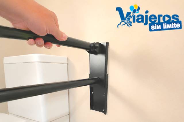 Barra abatible integrada en un baño accesible con diseño discreto y funcional